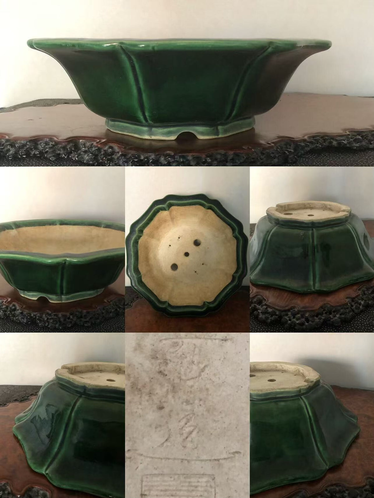A glossy green glazed pot with flared sides and a scalloped rim, showing its base and drainage holes.