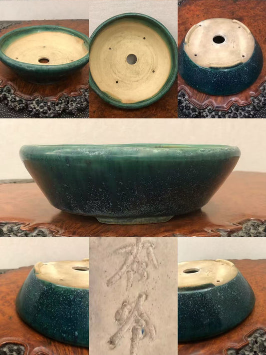 Dark green glazed pot with speckles, shallow bowl shape, and carved characters on base.