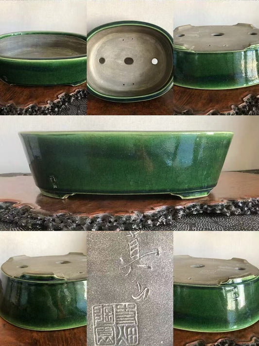 A glossy green ceramic bonsai pot with three drainage holes and a square maker's mark.