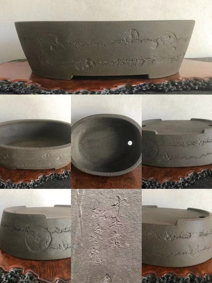 Dark grey unglazed ceramic pot with carved floral and circular patterns, showing interior and exterior views.