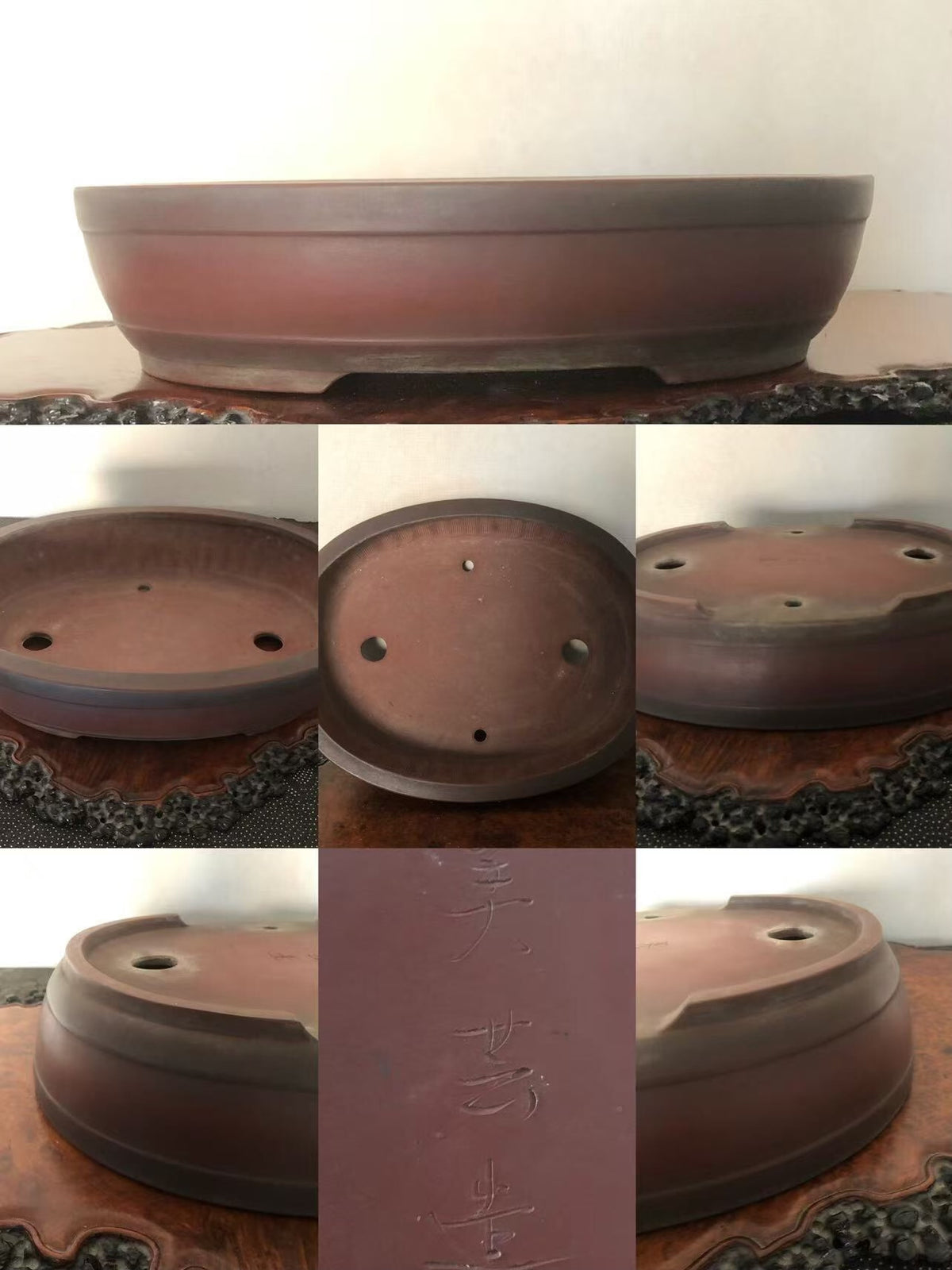 A reddish-brown ceramic bonsai pot with a wide rim, three drainage holes, and incised characters on its base.