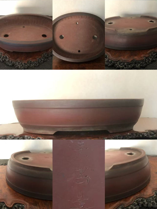 A reddish-brown ceramic bonsai pot with a wide rim, three drainage holes, and incised characters on its base.