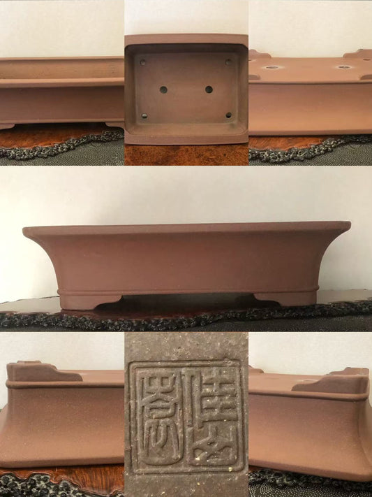 Rectangular terracotta bonsai pot with raised edges, unglazed matte finish, and carved square seal on base.
