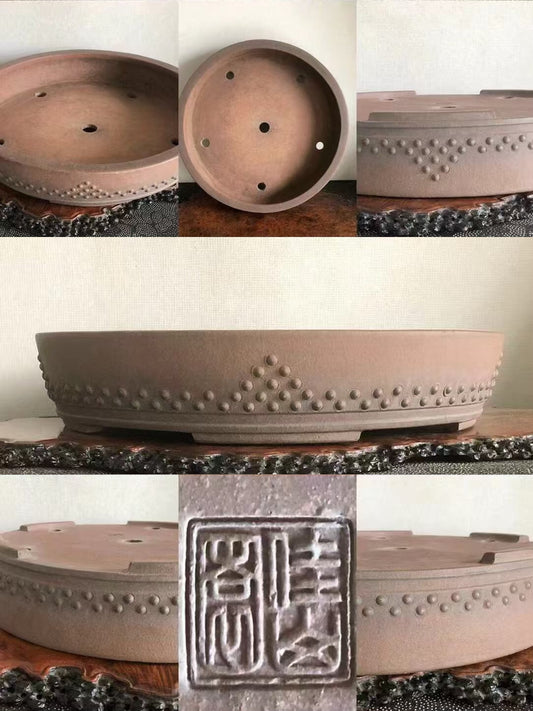 A matte brown ceramic bonsai pot with a beaded rim and a square carved seal on its base.
