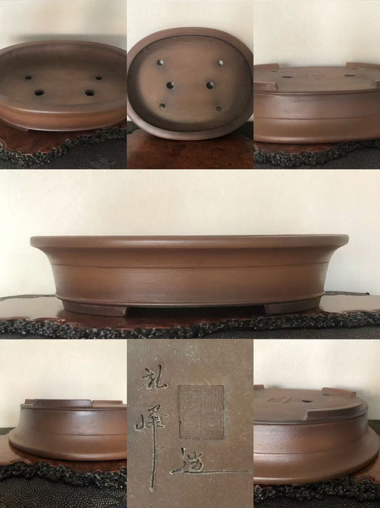 A brown, unglazed ceramic bonsai pot with a low, wide rim and four drainage holes.