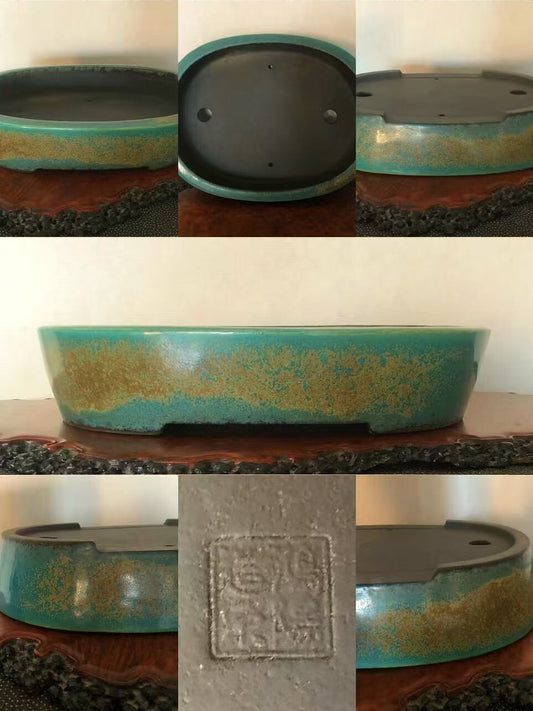 A glazed bonsai pot with a turquoise and gold speckled finish, showing its base and drainage holes.