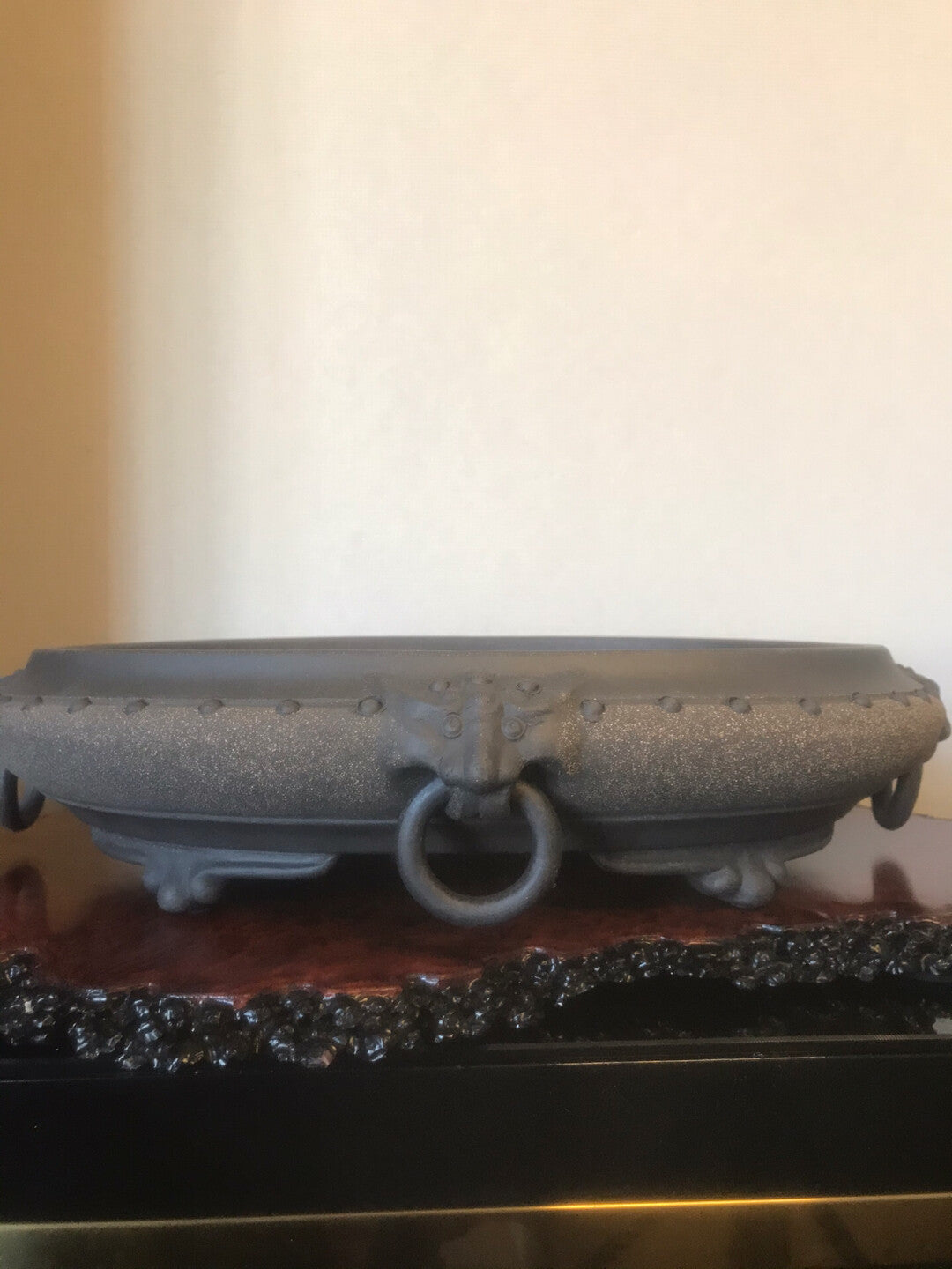 Dark grey, matte-finished ceramic pot with a central ring handle and rivet-like details.
