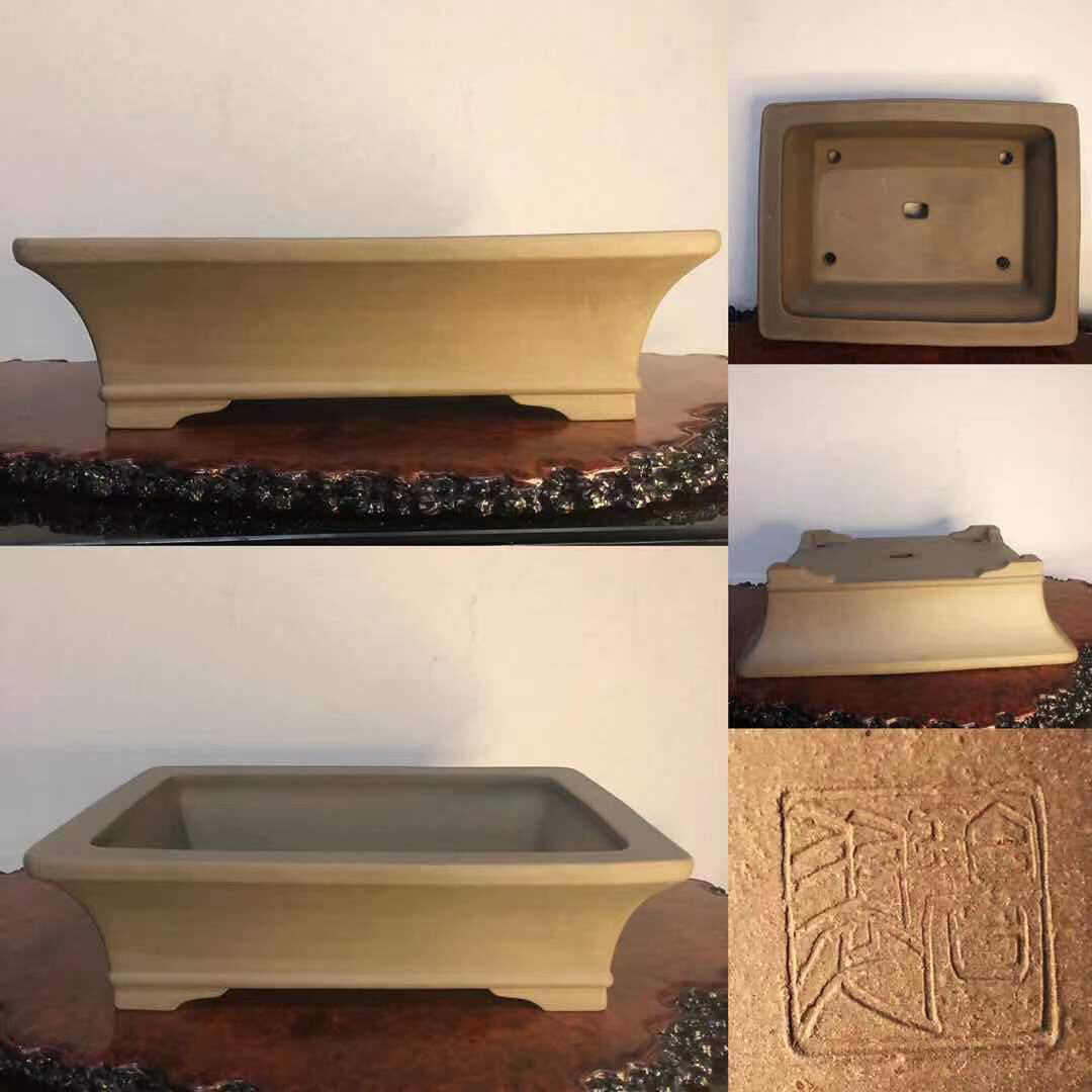 Rectangular beige unglazed ceramic bonsai pot with carved seal mark and four footed base.