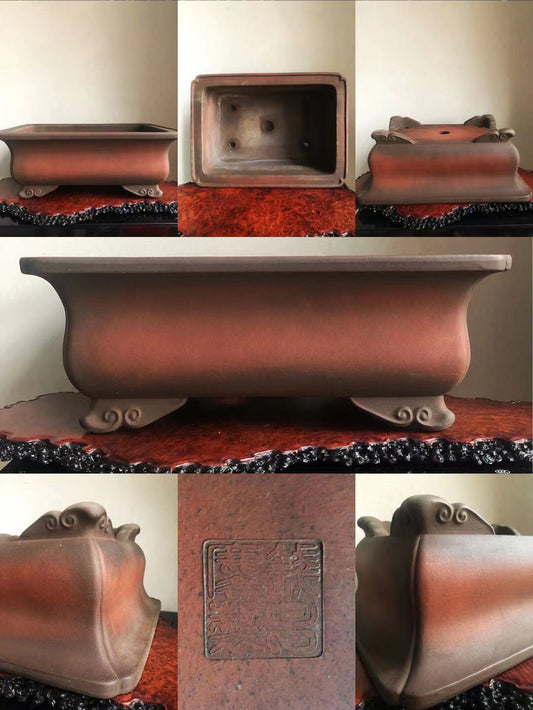 A reddish-brown glazed rectangular pot with four ornate feet and an embossed square seal on its base.