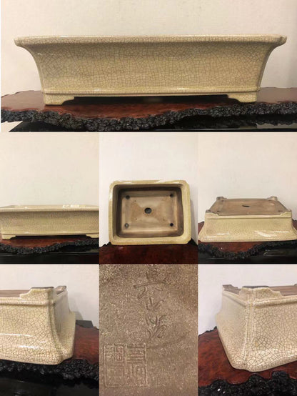 A rectangular, beige-glazed ceramic pot with a crackled surface and carved characters on its base.