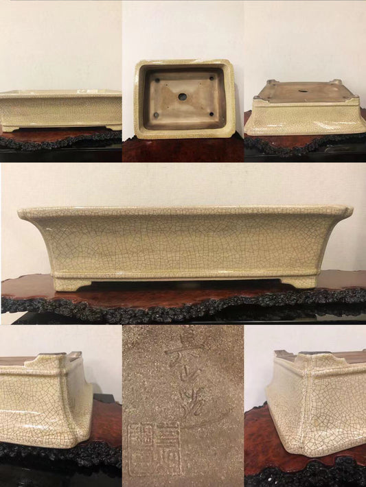 A rectangular, beige-glazed ceramic pot with a crackled surface and carved characters on its base.
