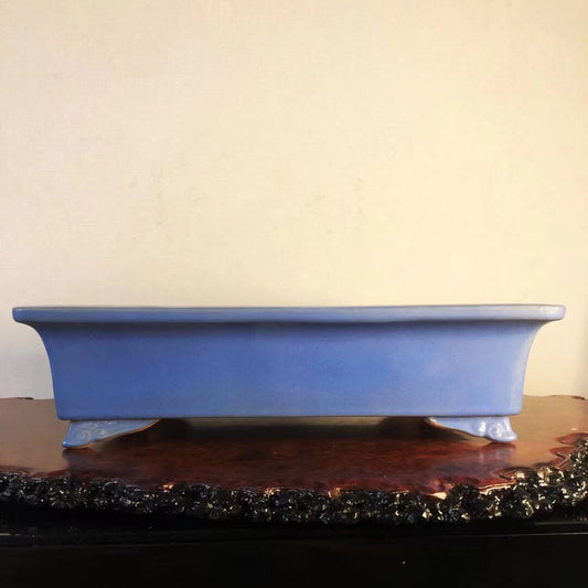 A blue glazed rectangular bonsai pot with a circular stamped mark on its base.