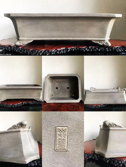 Grey rectangular pot with carved feet and a vertical stamped mark on its side.