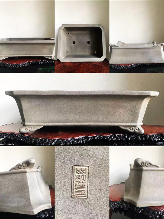 Grey rectangular pot with carved feet and a vertical stamped mark on its side.