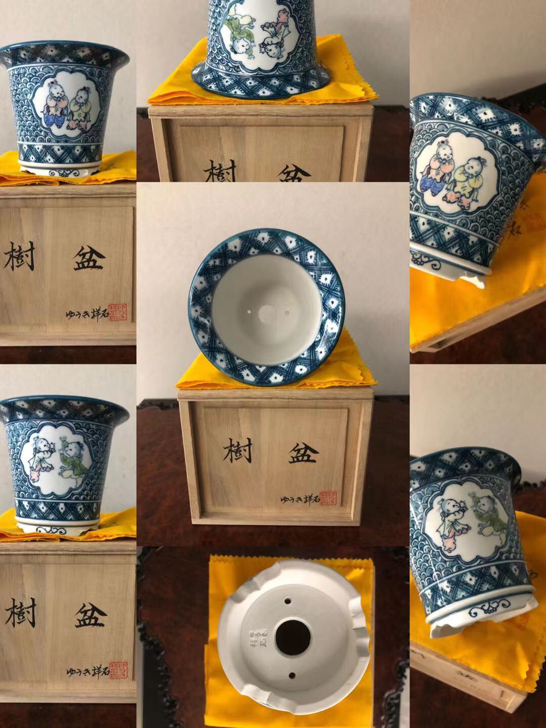 Blue and white ceramic pot with painted children scene, sits on yellow cloth in wooden box.