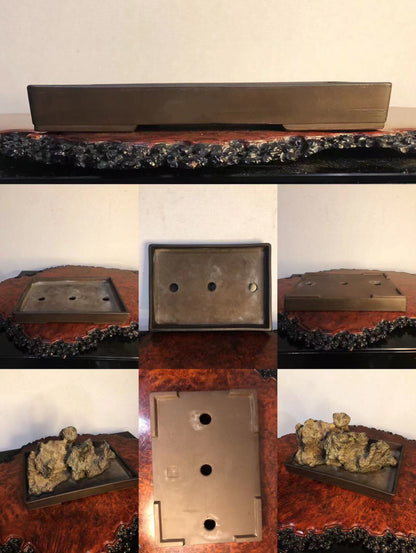 A rectangular, matte, dark brown ceramic bonsai pot with three drainage holes and a rough, textured base.
