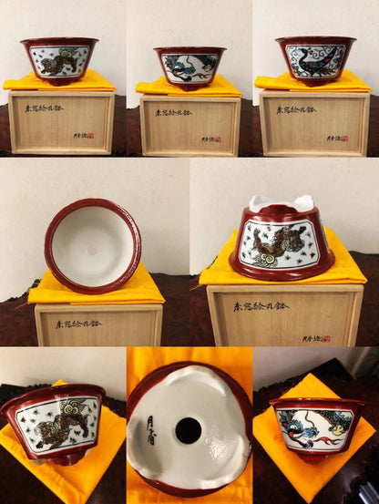 Three glazed ceramic pots with red rims, white interiors, and black dragon motifs on a yellow cloth.