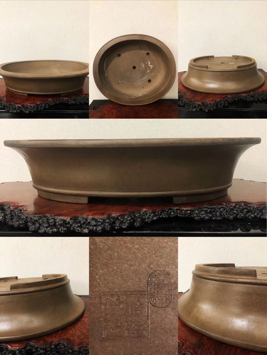A matte brown ceramic bonsai pot with a wide rim and drainage holes, showing its base and interior.