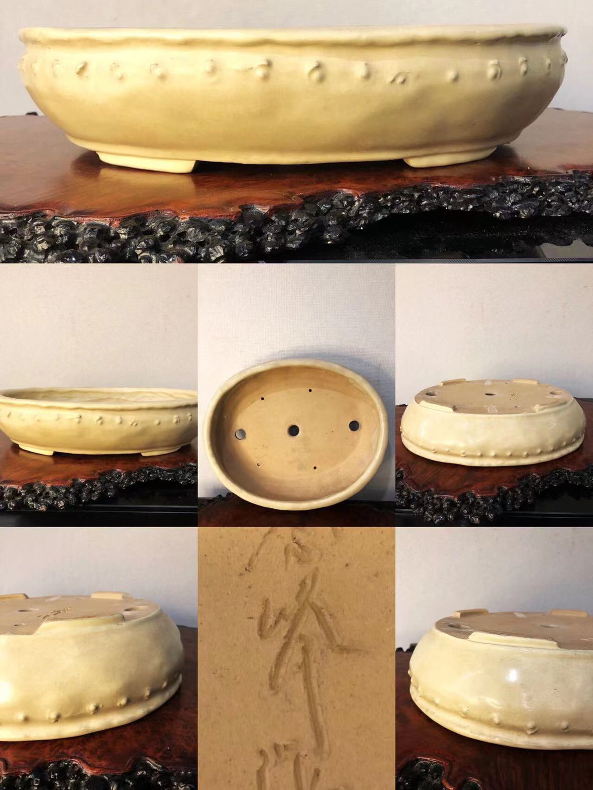 A pale yellow glazed ceramic pot with raised dots and carved characters on its base.