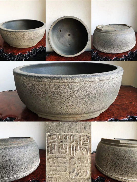 A speckled grey glazed pot with a wide rim and carved seal mark.