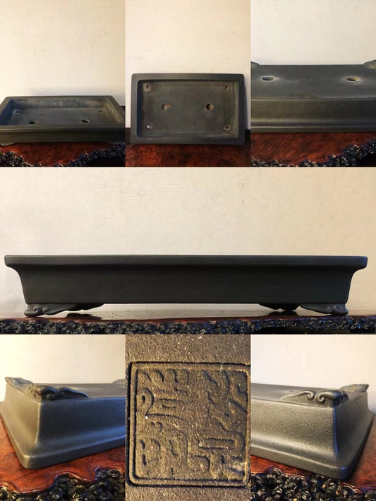 Dark grey rectangular pot with carved seal and two drainage holes, matte finish.