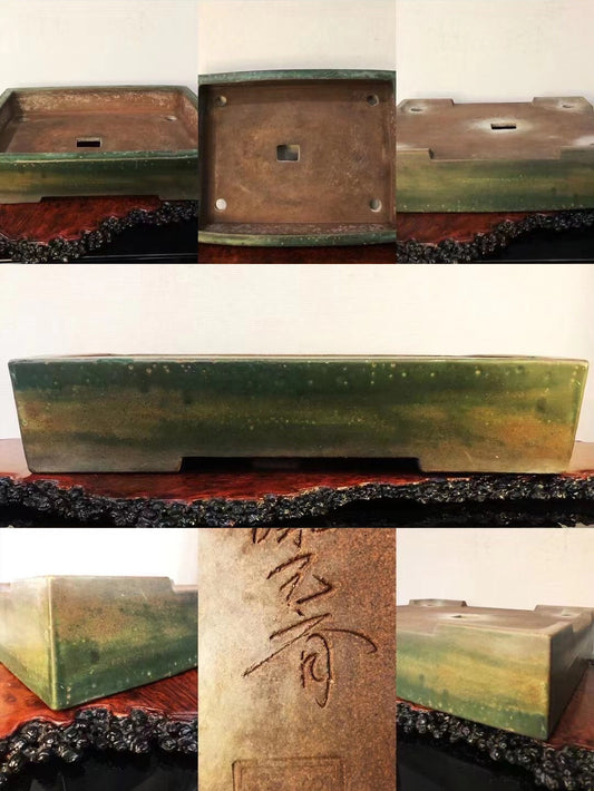 Rectangular glazed pot with green and brown mottled glaze, unglazed base with carved characters.