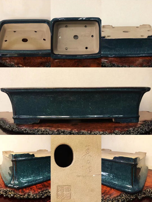Dark teal glazed rectangular pot with rounded corners, unglazed interior, and visible maker's mark.