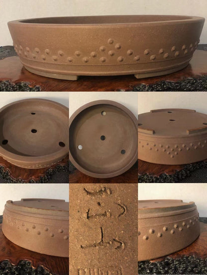 Brown unglazed ceramic pot with raised dot pattern and carved marks on base.