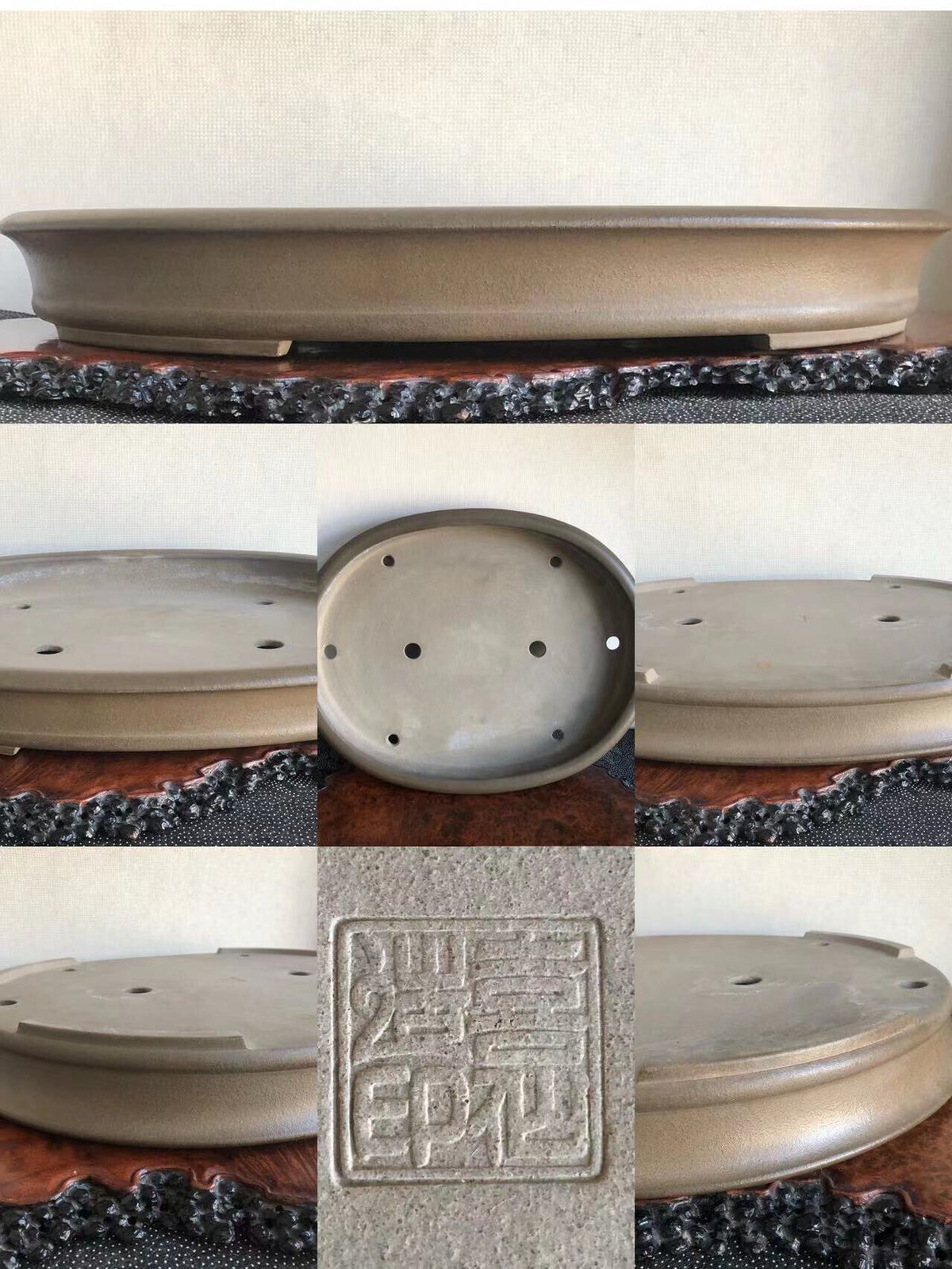 A matte grey ceramic bonsai pot with a square seal mark and drainage holes.