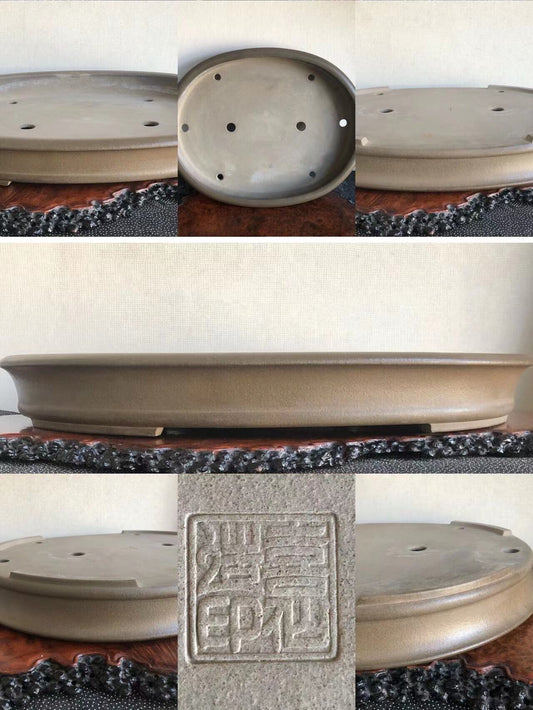 A matte grey ceramic bonsai pot with a square seal mark and drainage holes.