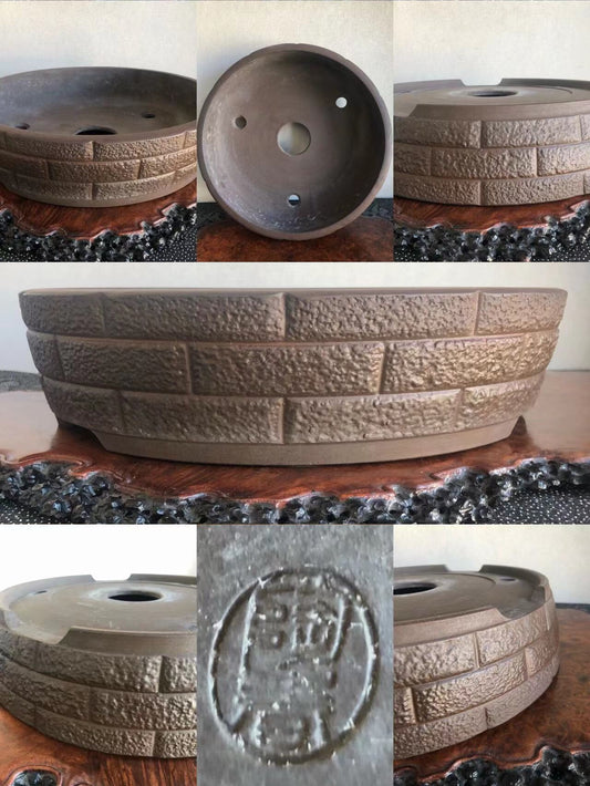 A single brown glazed pot with a brick-patterned texture and a stamped seal on its base.