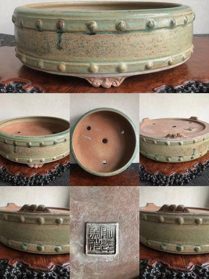 A green glazed ceramic pot with raised bumps and a square maker's mark.