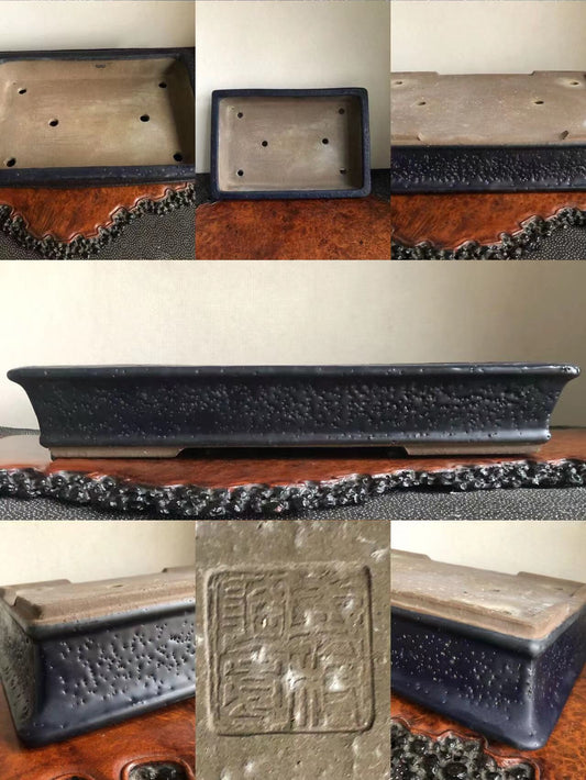 Rectangular dark glazed pot with textured surface and stamped square mark on base.