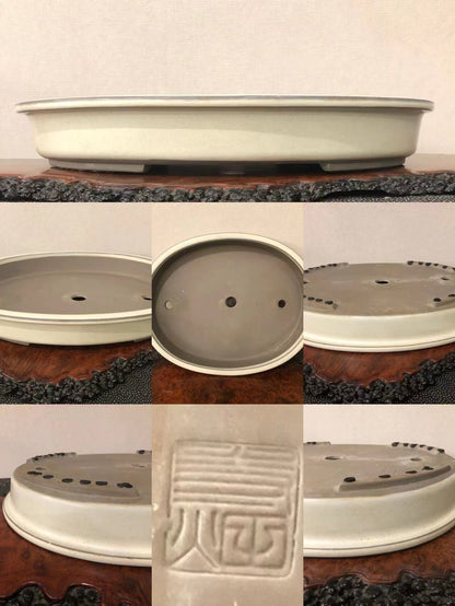 A light grey glazed bonsai pot with a single carved seal mark on its base.
