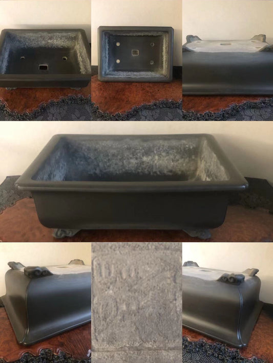 Dark grey rectangular pot with textured glaze, four feet, and engraved markings on base.
