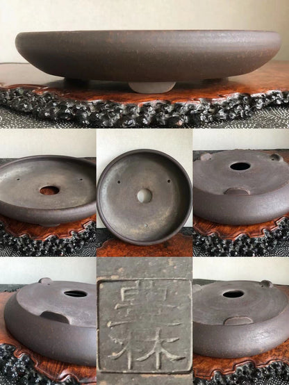 Dark brown glazed ceramic bonsai pot base with three drainage holes and a carved seal.