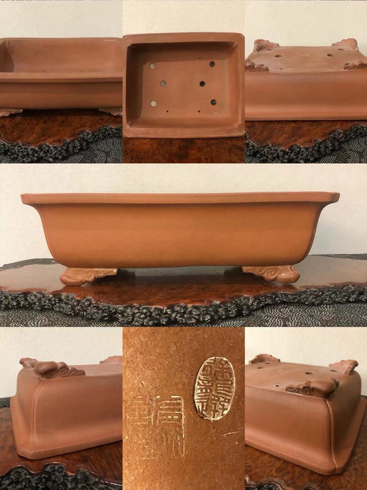 A terracotta bonsai pot with a rectangular shape, four feet, and an oval maker's mark.