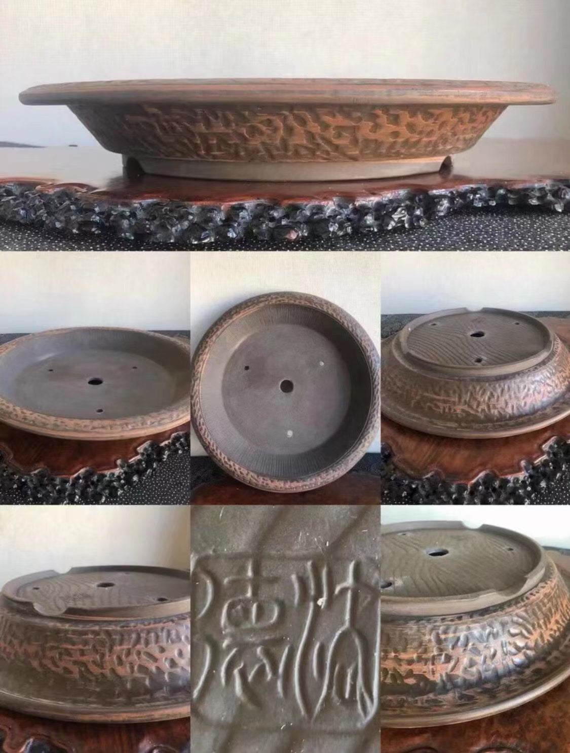 A dark brown glazed ceramic bonsai pot with carved patterns and a visible maker's mark.