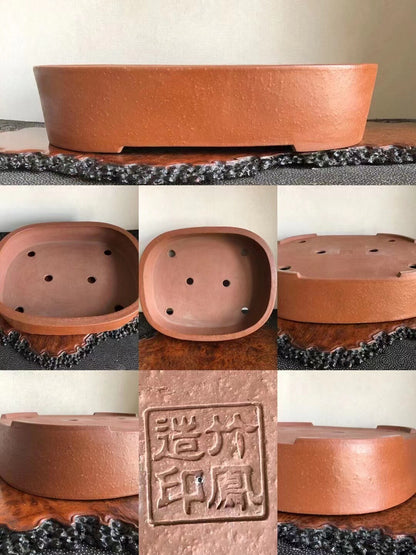 A terracotta bonsai pot base with four drainage holes and a square maker's seal.