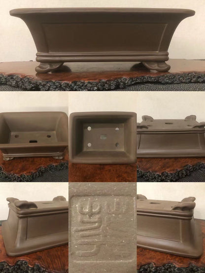Dark brown glazed rectangular pot with carved character mark and four feet.