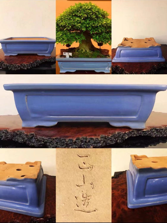 A blue glazed rectangular pot with a wooden insert and a visible maker's mark.
