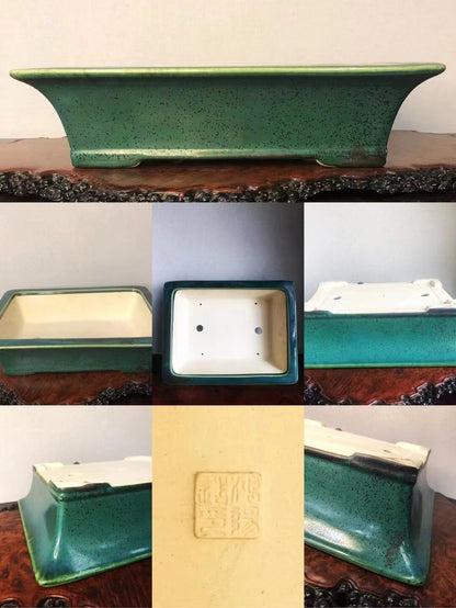 A green speckled glazed rectangular pot with a cream interior and a square maker's mark.