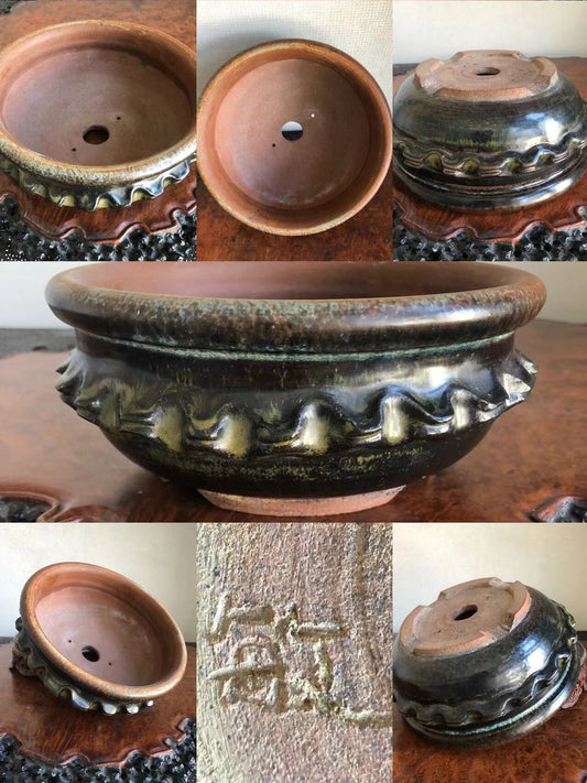 Dark glazed pot with scalloped rim, showing interior, base, and maker's mark.