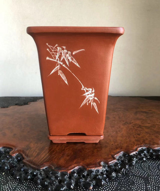 Rectangular terracotta pot with white bamboo motif, matte finish, sits on wooden tray.
