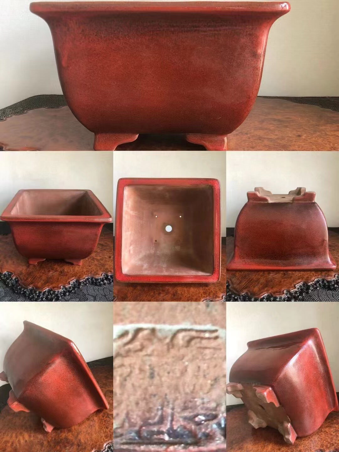 A square red glazed pot with a glossy finish and a small central hole in the base.