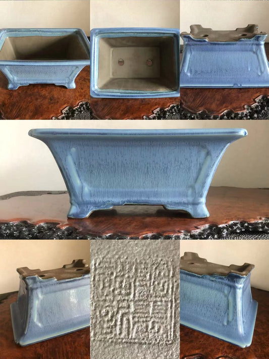 A light blue glazed rectangular pot with a textured surface and a stamped mark on its base.