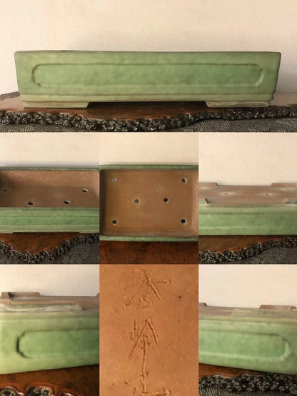 Rectangular green glazed pot with carved characters and drainage holes on base.