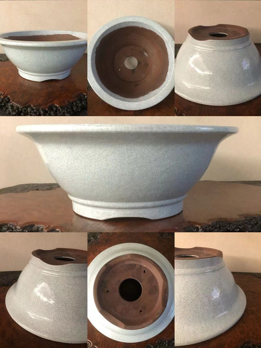 A wide, shallow ceramic pot with a crackled glaze and unglazed brown interior.