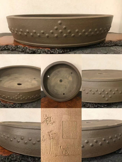 Dark brown glazed pot with raised dot pattern and carved characters on its base.