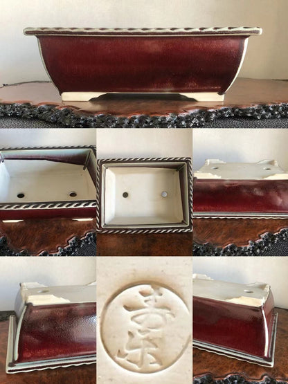 A rectangular bonsai pot with a glossy deep red glaze and a white interior, featuring a raised circular mark with characters.